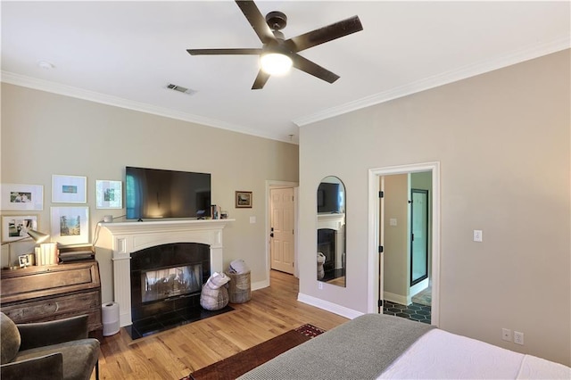 18123 Cusachs Dr, Covington, LA 70433 - bedroom featuring a fireplace with flush hearth, ornamental molding, wood finished floors, baseboards, and ceiling fan