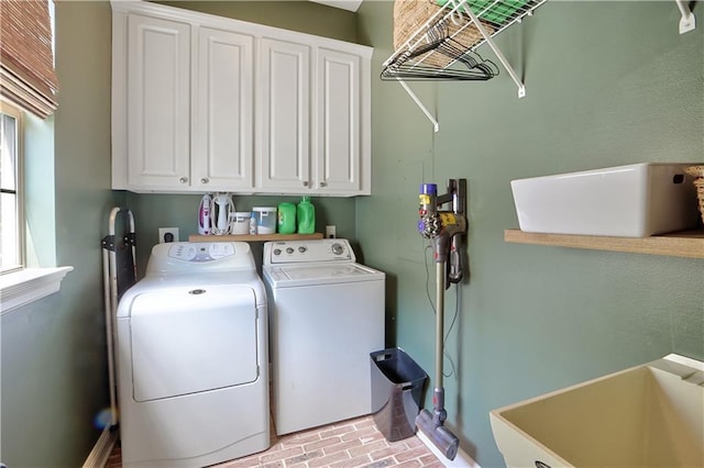 18123 Cusachs Dr, Covington, LA 70433 - laundry room featuring independent washer and dryer, cabinet space, and brick patterned flooring