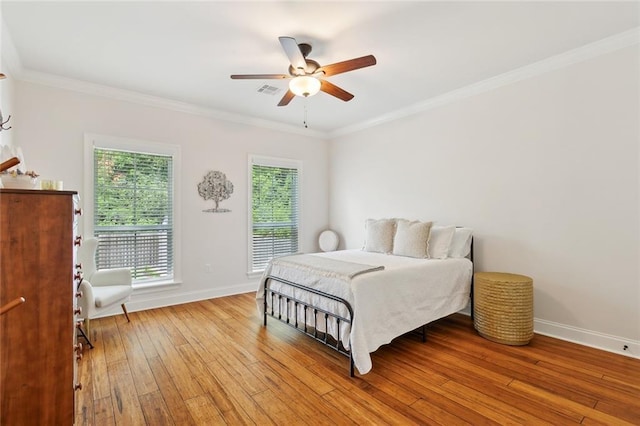 502 W 7th Ave, Covington, LA 70433 - bedroom with baseboards, light wood-type flooring, ornamental molding, and a ceiling fan