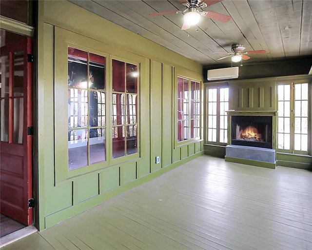 4445 Demontluzin St, New Orleans, LA 70122 - unfurnished living room featuring a wall unit AC, ceiling fan, a lit fireplace, wood finished floors, and healthy amount of natural light