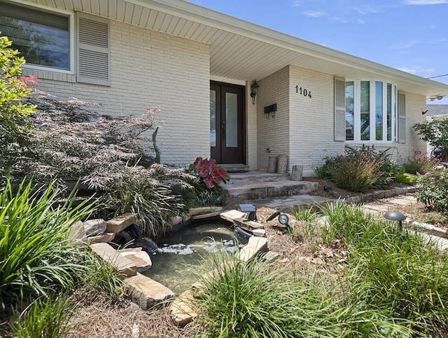 1104 Sena Dr, Metairie, LA 70005 - view of exterior entry with brick siding and a garden pond