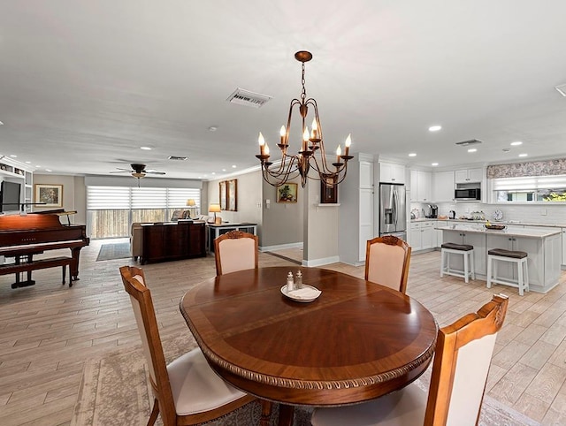1104 Sena Dr, Metairie, LA 70005 - dining area featuring healthy amount of natural light, recessed lighting, light wood-style floors, a chandelier, and ceiling fan