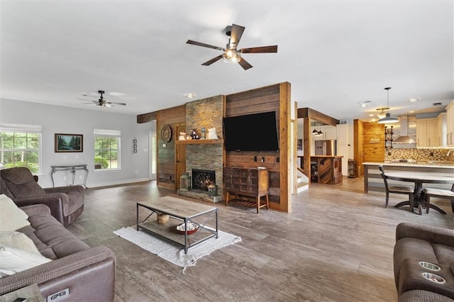 23375 Lowe Davis Rd, Covington, LA 70435 - living room with a ceiling fan, wood finished floors, baseboards, and a stone fireplace