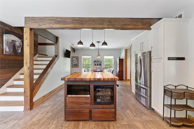23375 Lowe Davis Rd, Covington, LA 70435 - dining area featuring light wood-style floors, stairs, beamed ceiling, and baseboards