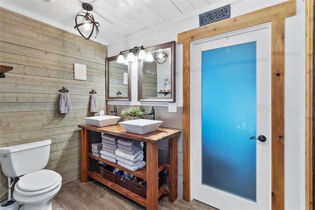 23375 Lowe Davis Rd, Covington, LA 70435 - bathroom with wood walls, double vanity, toilet, and wood finished floors