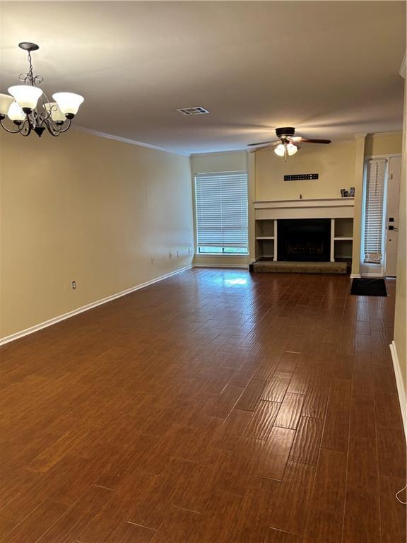 2836 Steamship Cir Unit A, River Ridge, LA 70123 - unfurnished living room featuring a chandelier, ceiling fan, dark wood-type flooring, and a fireplace with raised hearth