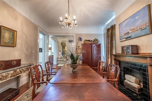 212 Linton Ave, Natchez-Ms, MS 39120 - dining room featuring a chandelier, a tiled fireplace, and wood finished floors