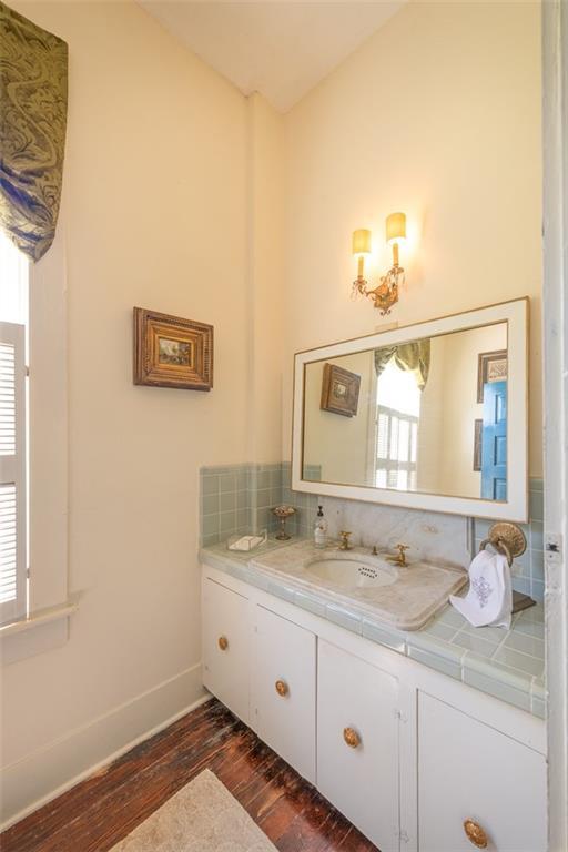 212 Linton Ave, Natchez-Ms, MS 39120 - bathroom featuring hardwood / wood-style floors, vanity, baseboards, and backsplash