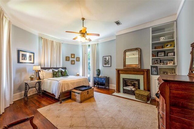 212 Linton Ave, Natchez-Ms, MS 39120 - bedroom with crown molding, baseboards, wood finished floors, a ceiling fan, and a fireplace with flush hearth