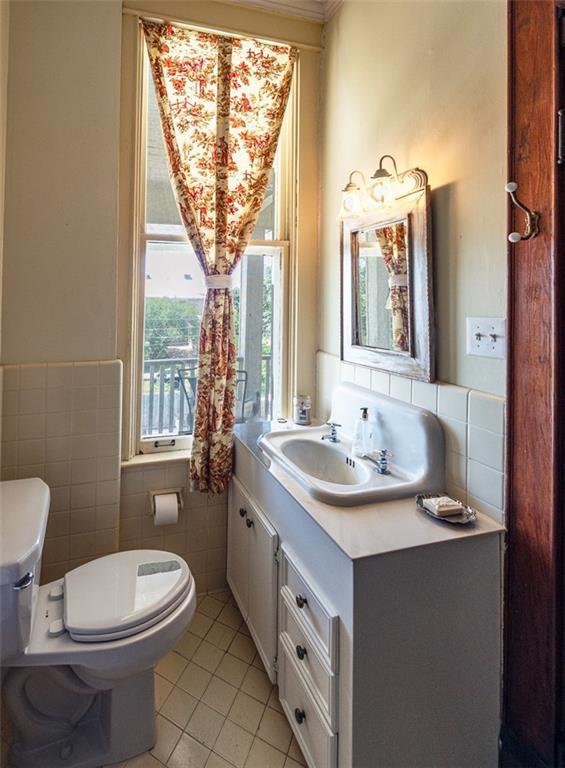 212 Linton Ave, Natchez-Ms, MS 39120 - bathroom featuring toilet, tile patterned flooring, vanity, tile walls, and ornamental molding