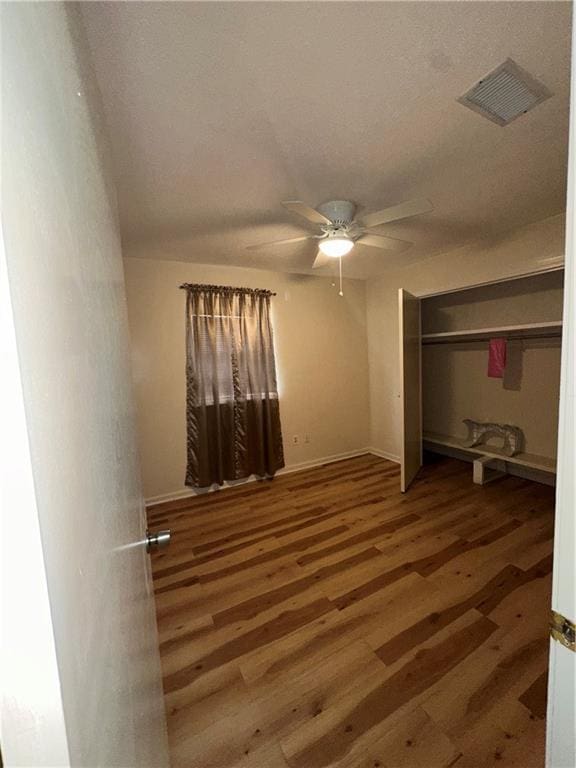 70915 S Gayoso St, New Orleans, LA 70119 - unfurnished bedroom with wood finished floors, a ceiling fan, and baseboards