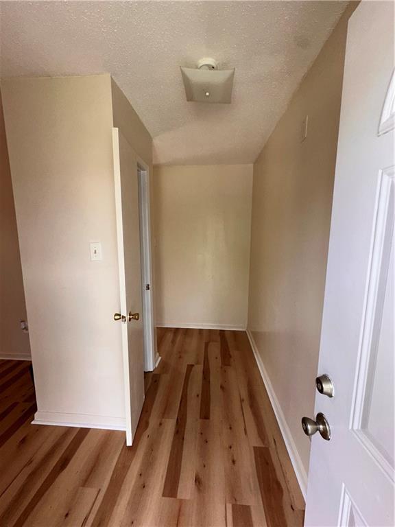 70915 S Gayoso St, New Orleans, LA 70119 - corridor featuring wood finished floors, baseboards, and a textured ceiling