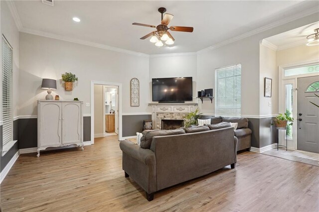 1400 Viola St, Mandeville, LA 70448 - living room featuring a ceiling fan, light wood-type flooring, a fireplace, baseboards, and ornamental molding