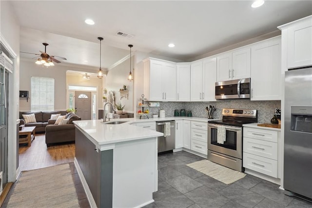 1400 Viola St, Mandeville, LA 70448 - kitchen featuring appliances with stainless steel finishes, a peninsula, a sink, open floor plan, and backsplash