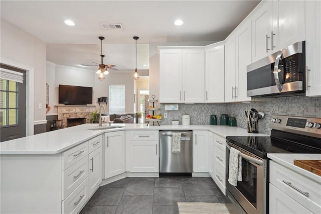 1400 Viola St, Mandeville, LA 70448 - kitchen featuring stainless steel appliances, a sink, a peninsula, open floor plan, and backsplash