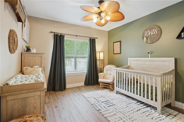 1400 Viola St, Mandeville, LA 70448 - bedroom with baseboards, a nursery area, light wood-type flooring, and a ceiling fan