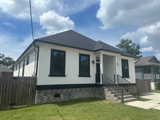 1731 Pratt Dr, New Orleans, LA 70122 - view of front of home with stucco siding, a shingled roof, and crawl space