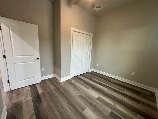 1731 Pratt Dr, New Orleans, LA 70122 - unfurnished bedroom featuring dark wood finished floors, baseboards, a closet, and vaulted ceiling
