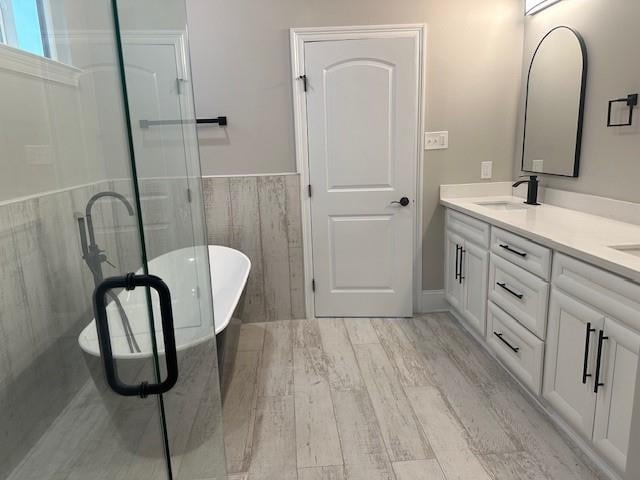 1731 Pratt Dr, New Orleans, LA 70122 - bathroom with double vanity, tile walls, wood finished floors, a freestanding tub, and a shower stall