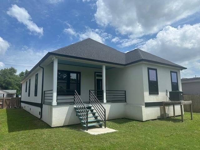 1731 Pratt Dr, New Orleans, LA 70122 - back of house with covered porch, stucco siding, a shingled roof, and stairs