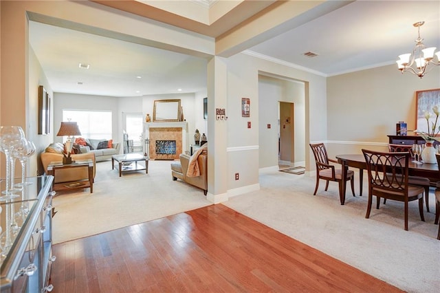 39070 Pirogue Ave, Gonzales, LA 70737 - living room featuring a chandelier, wood finished floors, a fireplace, carpet, and ornamental molding