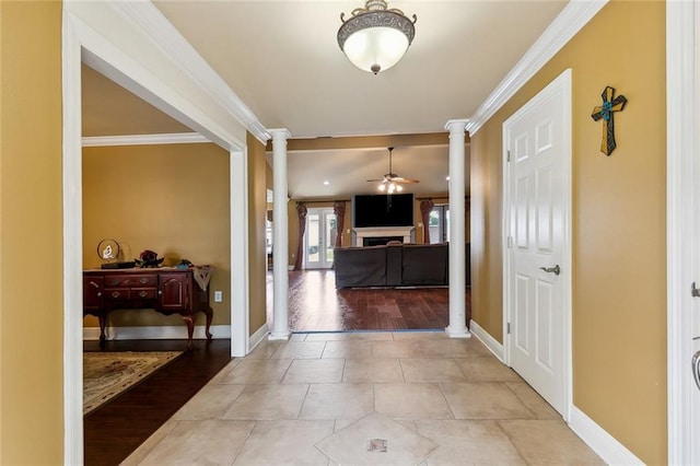1825 Lake Superior Dr, Harvey, LA 70058 - foyer with ornate columns, a fireplace, a ceiling fan, crown molding, and light wood-style flooring