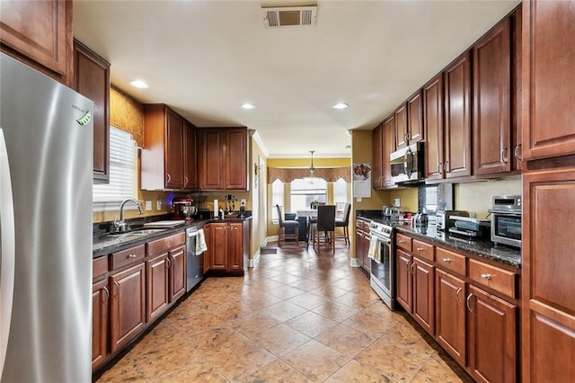 1825 Lake Superior Dr, Harvey, LA 70058 - kitchen with appliances with stainless steel finishes, a sink, recessed lighting, dark stone counters, and pendant lighting