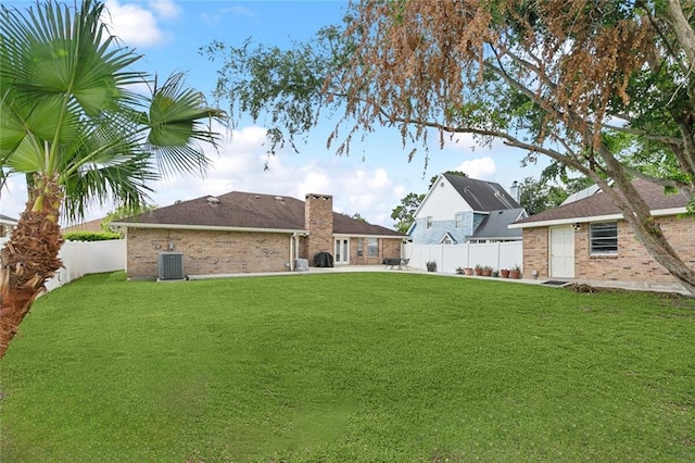 1825 Lake Superior Dr, Harvey, LA 70058 - back of property featuring central AC unit, brick siding, a patio, and a chimney