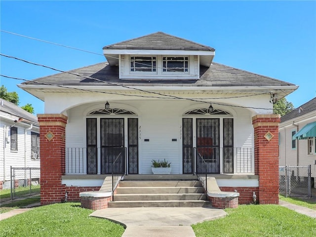 233537 Jasmine St, New Orleans, LA 70122 - view of front of house with covered porch, a shingled roof, and brick siding
