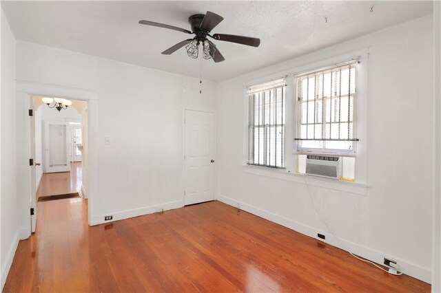 233537 Jasmine St, New Orleans, LA 70122 - empty room featuring wood finished floors, a chandelier, baseboards, and cooling unit