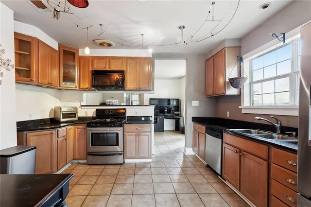 719 Atlantic Ave, New Orleans, LA 70114 - kitchen with appliances with stainless steel finishes, a sink, dark countertops, glass insert cabinets, and track lighting