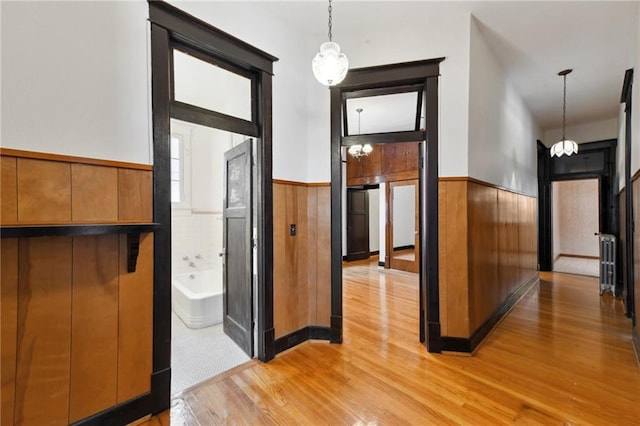 1311 Bourbon St, New Orleans, LA 70116 - entryway featuring a wainscoted wall, light wood-style flooring, and radiator heating unit