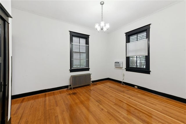 1311 Bourbon St, New Orleans, LA 70116 - unfurnished room with radiator heating unit, a chandelier, crown molding, wood finished floors, and baseboards