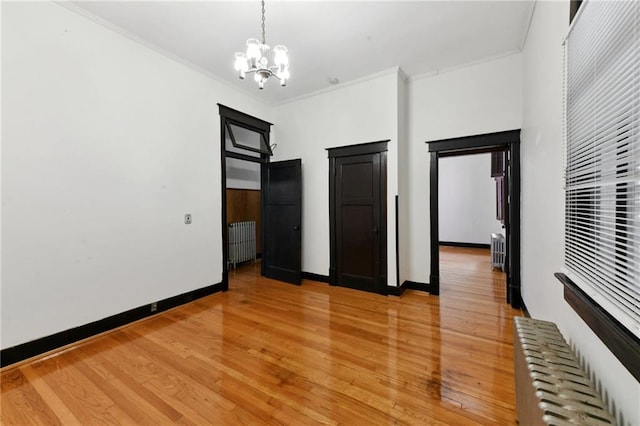 1311 Bourbon St, New Orleans, LA 70116 - unfurnished bedroom with radiator, a chandelier, ornamental molding, light wood-type flooring, and baseboards