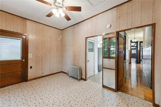 1311 Bourbon St, New Orleans, LA 70116 - spare room with radiator, ceiling fan, baseboards, and wood walls