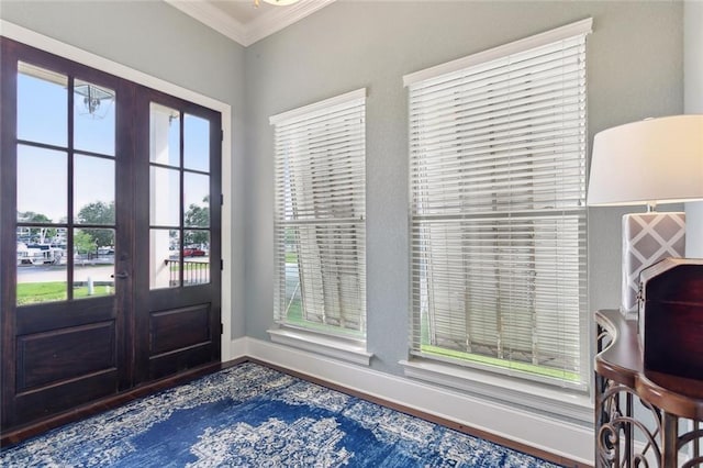 foyer entrance featuring french doors, baseboards, ornamental molding, and wood finished floors