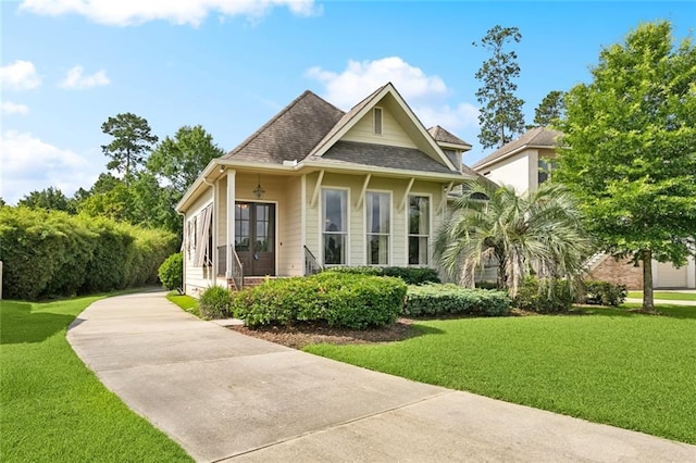 view of front facade with a front yard, driveway, and french doors