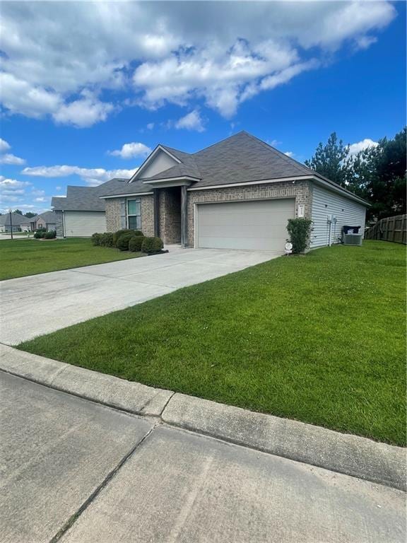 47715 Cathy Ln, Robert, LA 70455 - ranch-style home with a front yard, a garage, concrete driveway, cooling unit, and brick siding