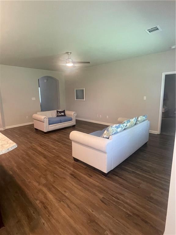 47715 Cathy Ln, Robert, LA 70455 - living area with dark wood-style floors, baseboards, a ceiling fan, and arched walkways