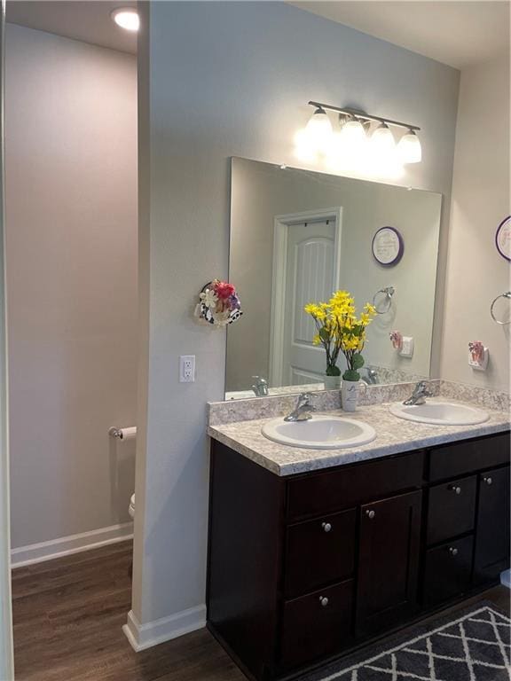 47715 Cathy Ln, Robert, LA 70455 - bathroom with toilet, double vanity, wood finished floors, and baseboards