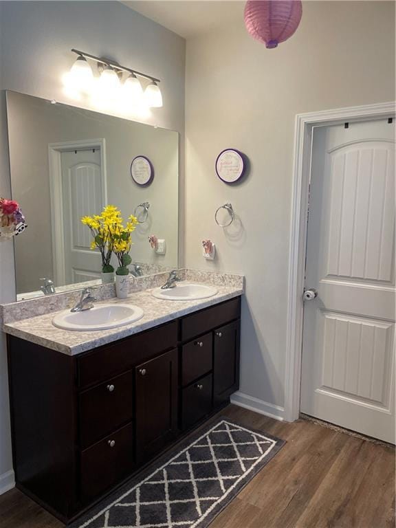47715 Cathy Ln, Robert, LA 70455 - full bath featuring double vanity, wood finished floors, and baseboards