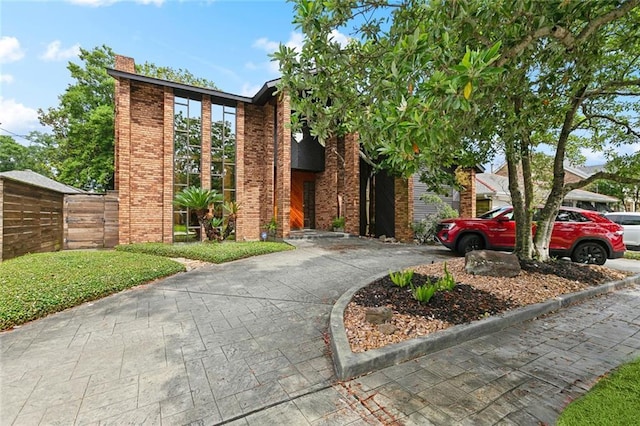 3213 Tolmas Dr, Metairie, LA 70002 - view of front of property featuring brick siding, driveway, and a chimney