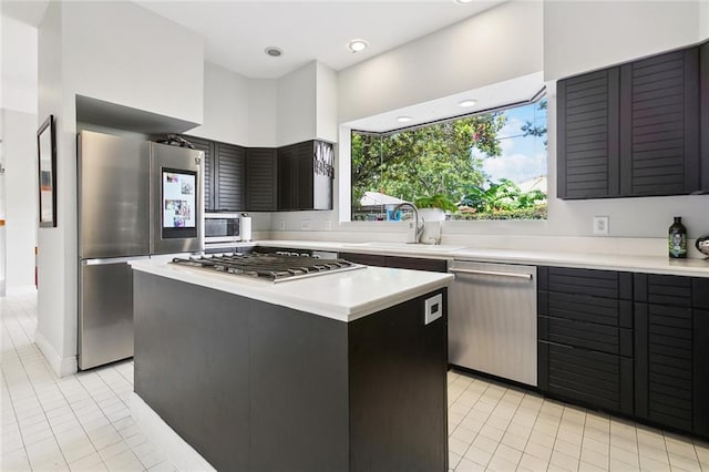3213 Tolmas Dr, Metairie, LA 70002 - kitchen featuring appliances with stainless steel finishes, light countertops, a sink, light tile patterned flooring, and a kitchen island