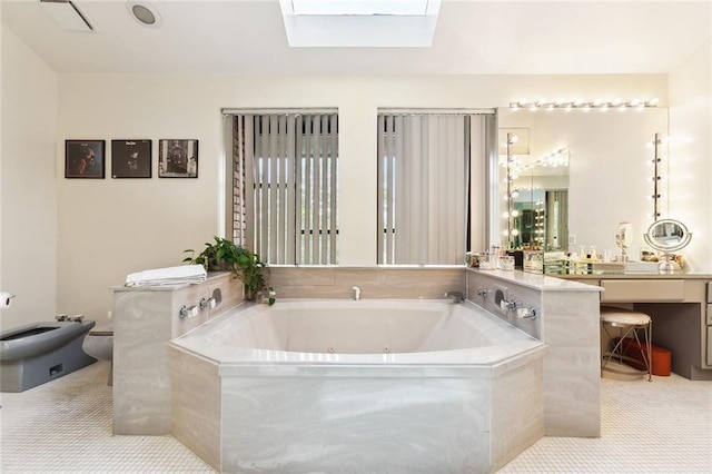 3213 Tolmas Dr, Metairie, LA 70002 - bathroom featuring a whirlpool tub, a skylight, a bidet, vanity, and toilet