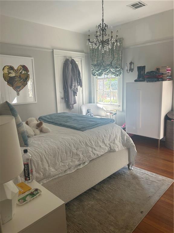 1222 Broadway St, New Orleans, LA 70118 - bedroom with a chandelier and wood finished floors