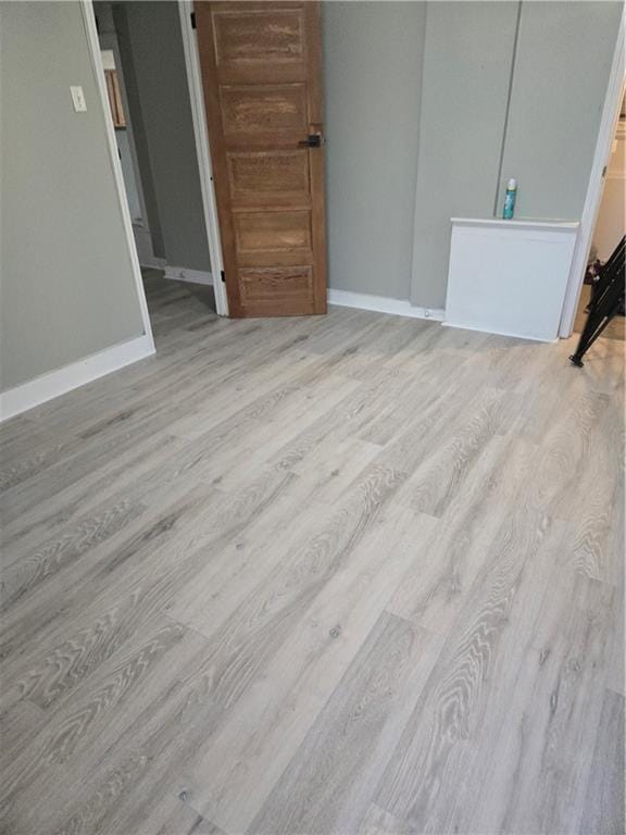1222 Broadway St, New Orleans, LA 70118 - unfurnished bedroom featuring wood finished floors, baseboards, and connected bathroom