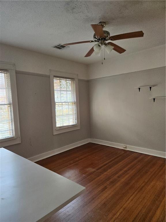 1222 Broadway St, New Orleans, LA 70118 - unfurnished room with dark wood-type flooring, baseboards, a ceiling fan, and a textured ceiling