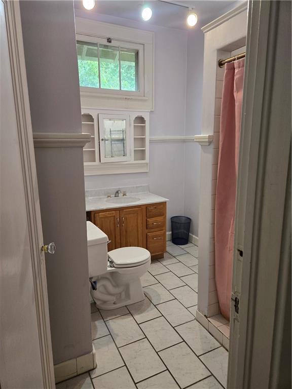 1222 Broadway St, New Orleans, LA 70118 - bathroom featuring toilet, vanity, a shower with shower curtain, and tile patterned floors