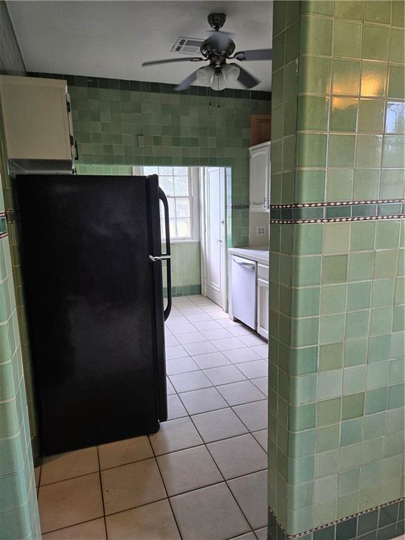 1222 Broadway St, New Orleans, LA 70118 - kitchen with freestanding refrigerator, dishwasher, white cabinetry, light tile patterned floors, and ceiling fan