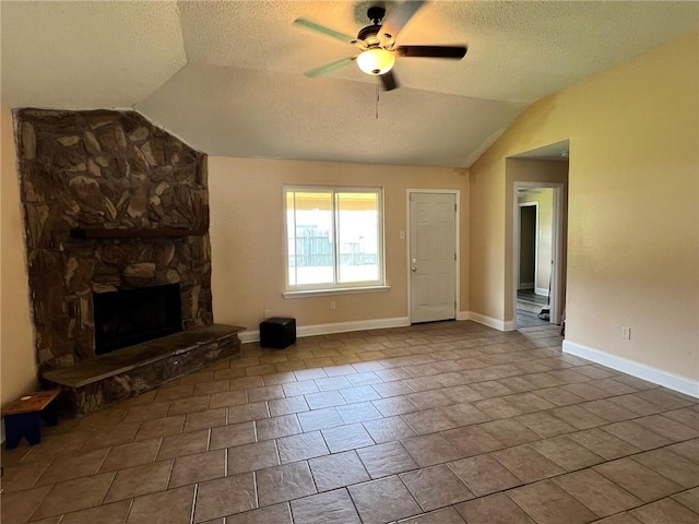 2506 S Sugar Ridge Dr, La Place, LA 70068 - unfurnished living room featuring vaulted ceiling, a textured ceiling, a ceiling fan, a stone fireplace, and baseboards